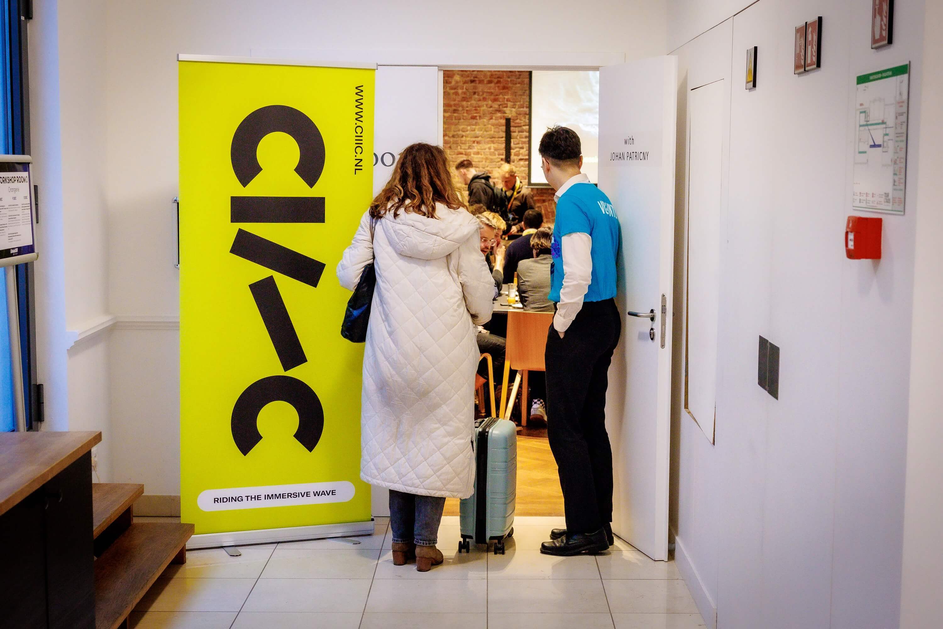 ingang naar de zaal voor ontbijtsessie met gele CIIIC-banner