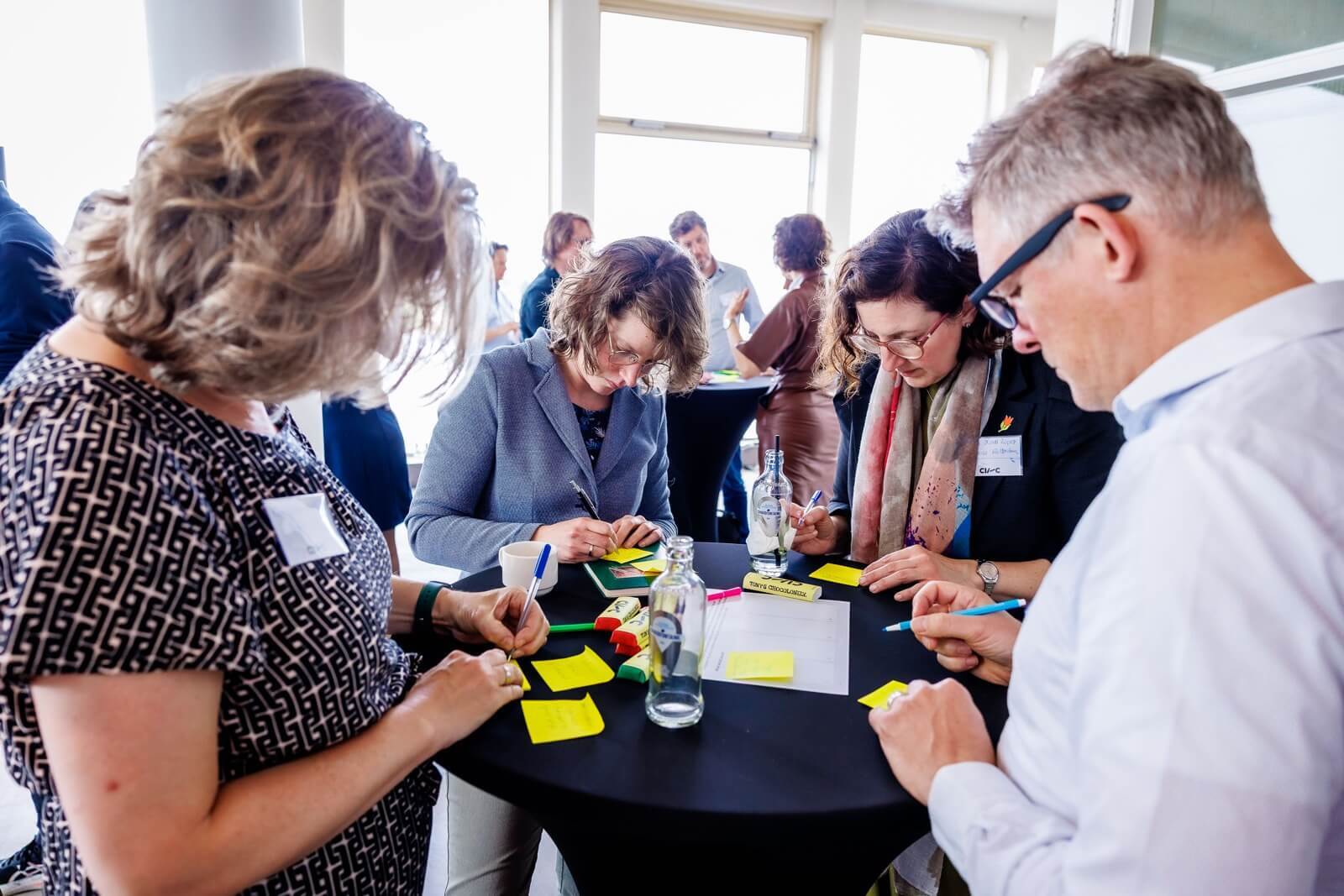 Workshop participants write something on post-its.